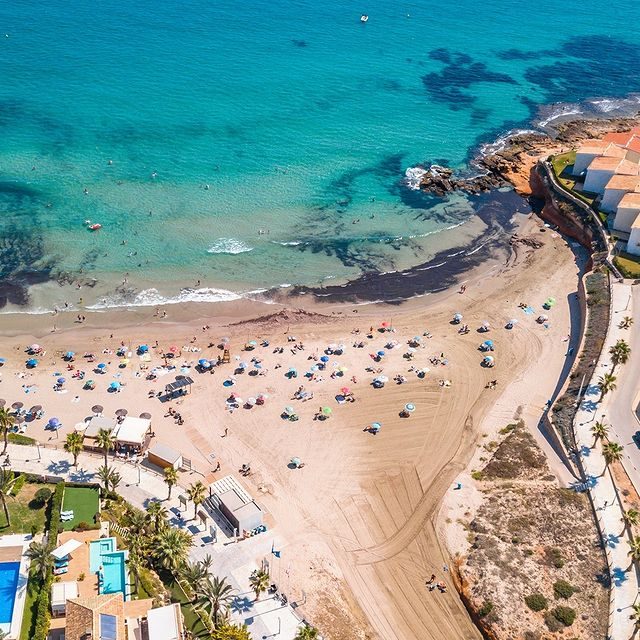 Strand met parasols aan turquoise zee
